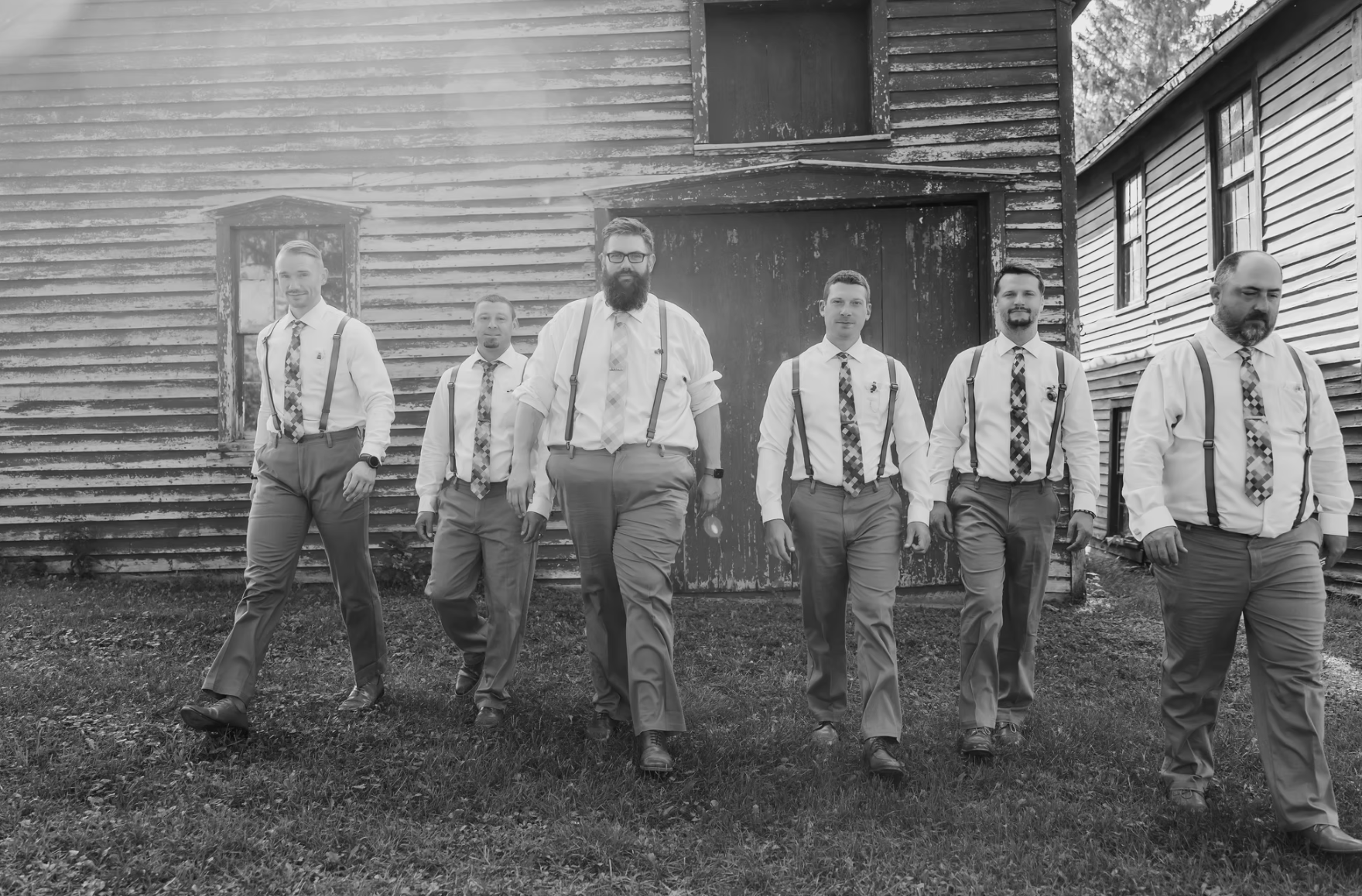 Groomsmen walking in front of a heritage village building