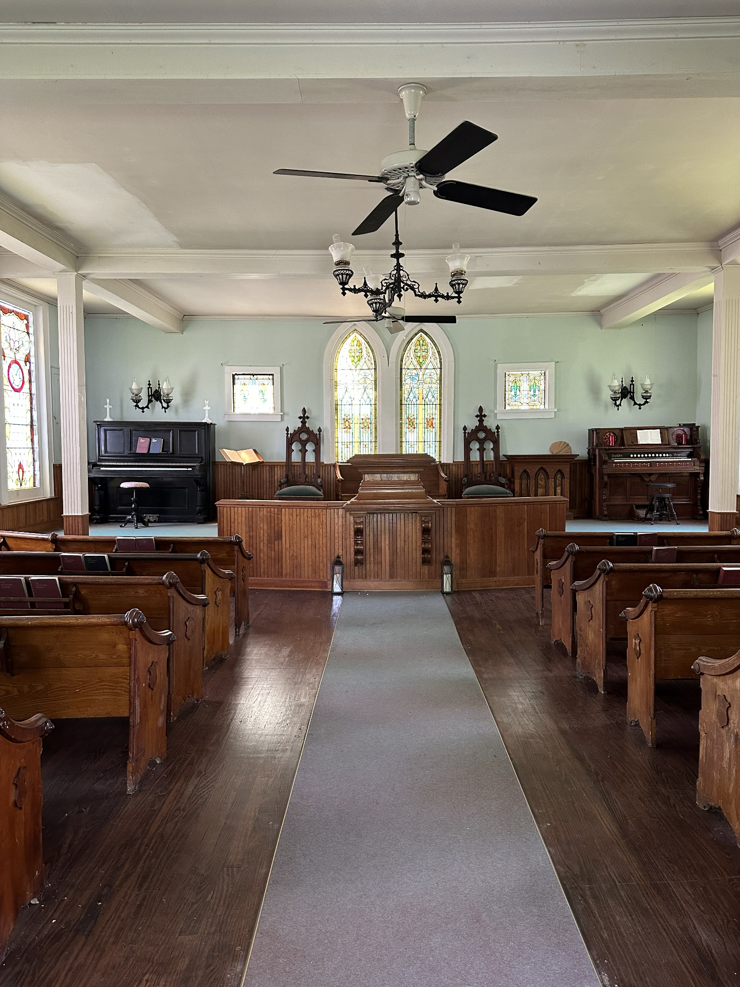 The altar of the Village Chapel with stained glass windows and antique organ